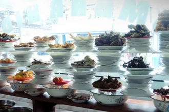 Warung nasi Padang dengan ciri khas menu tersusun di etalase.