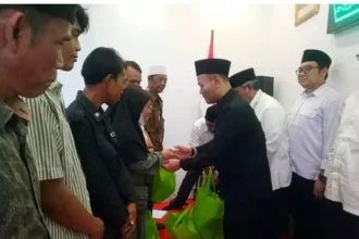 Enjat Mujiat saat menyerahkan santunan di aula kantor Kemenag Depok